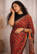 Beautiful Mirror Work Ajrakh Saree by MIZHI featuring traditional ajrak fabric with intricate mirror embellishments.