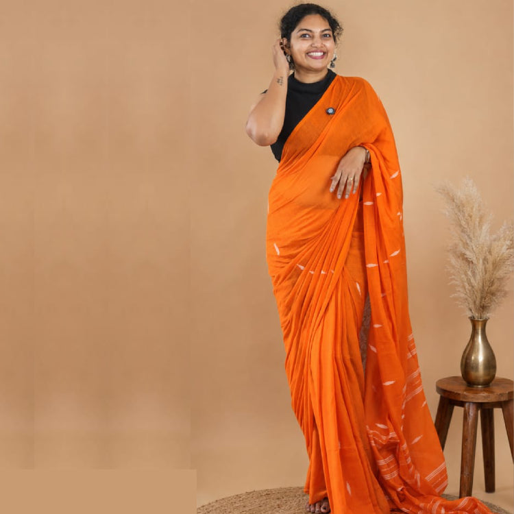 Vibrant orange Jamdani Mul Cotton Saree from MIZHI with intricate traditional patterns and a flowing, elegant drape.