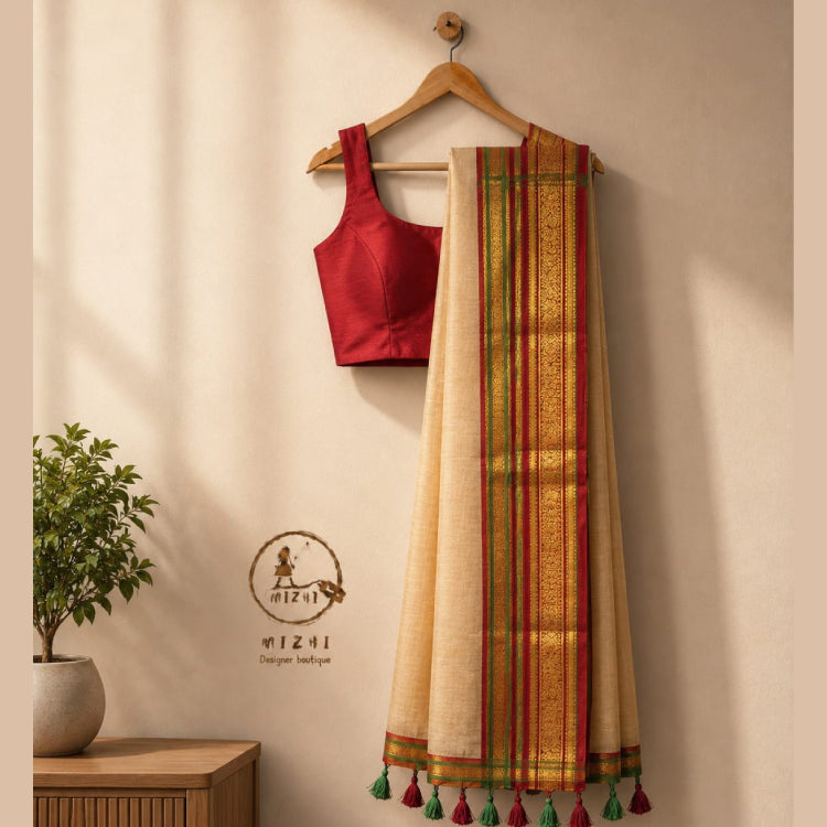 MIZHI premium beige mul cotton saree with intricate woven design, draped elegantly showcasing its soft, comfortable fabric.