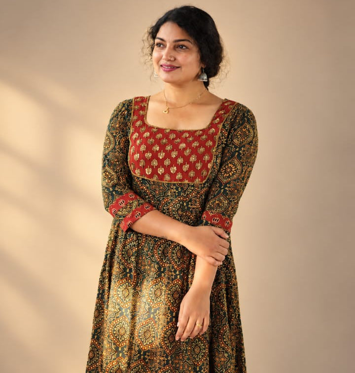 MIZHI paneled Anarkali Ajrakh dress with intricate ajrakh print and paneled design, displayed on a hanger.
